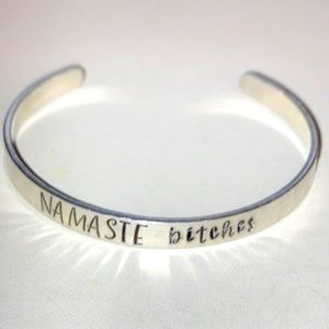 Open silver tone bangle bracelet w wording of Namaste Bitches on front. Bme3079